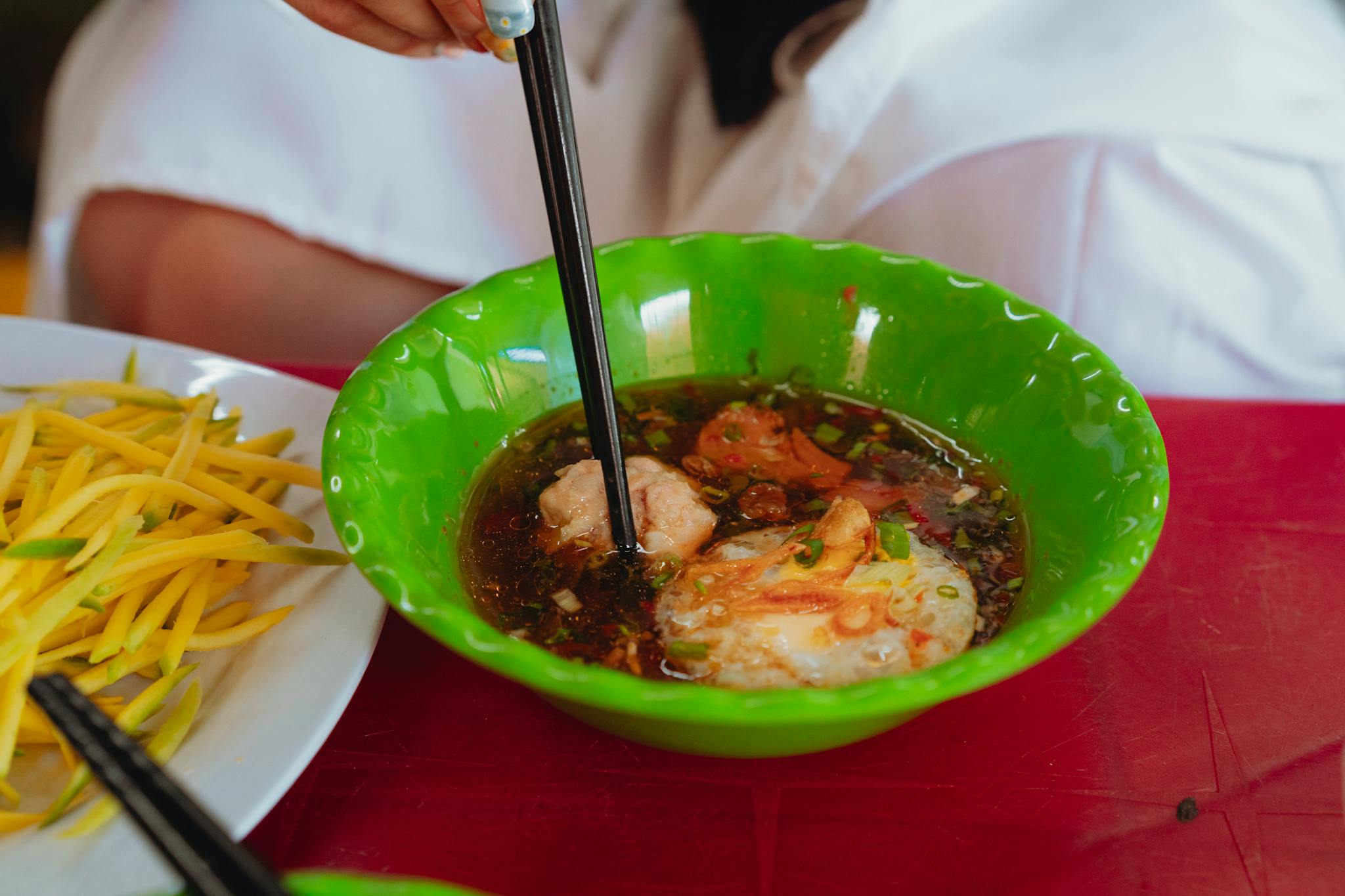 A flavorful Vietnamese soup with fresh shrimp and vegetables in a vibrant setting.