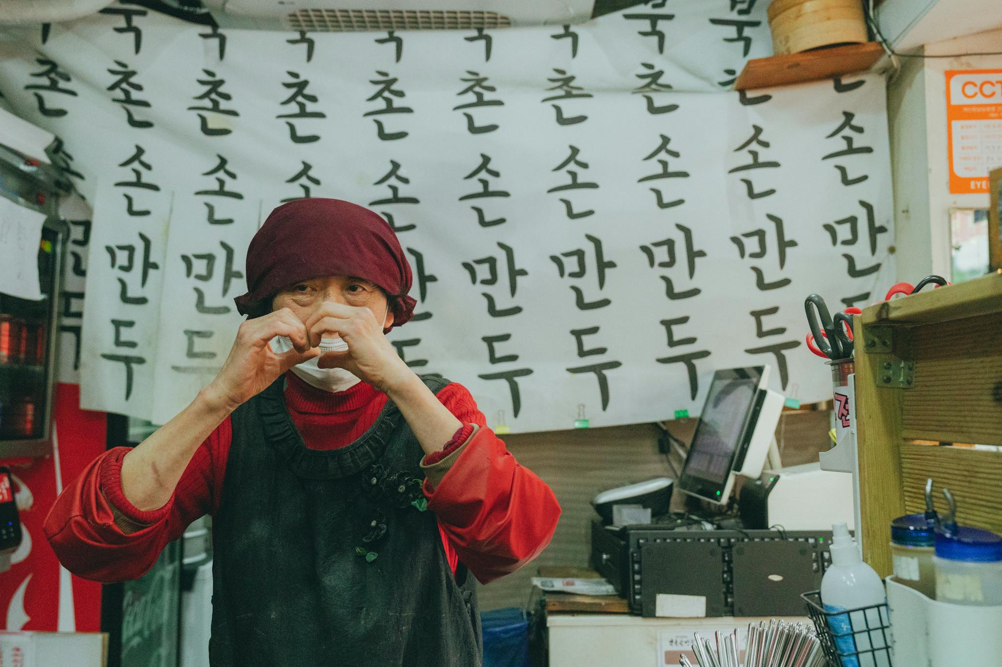 A Seoul street food vendor prepares traditional mandu dumplings in a bustling market.