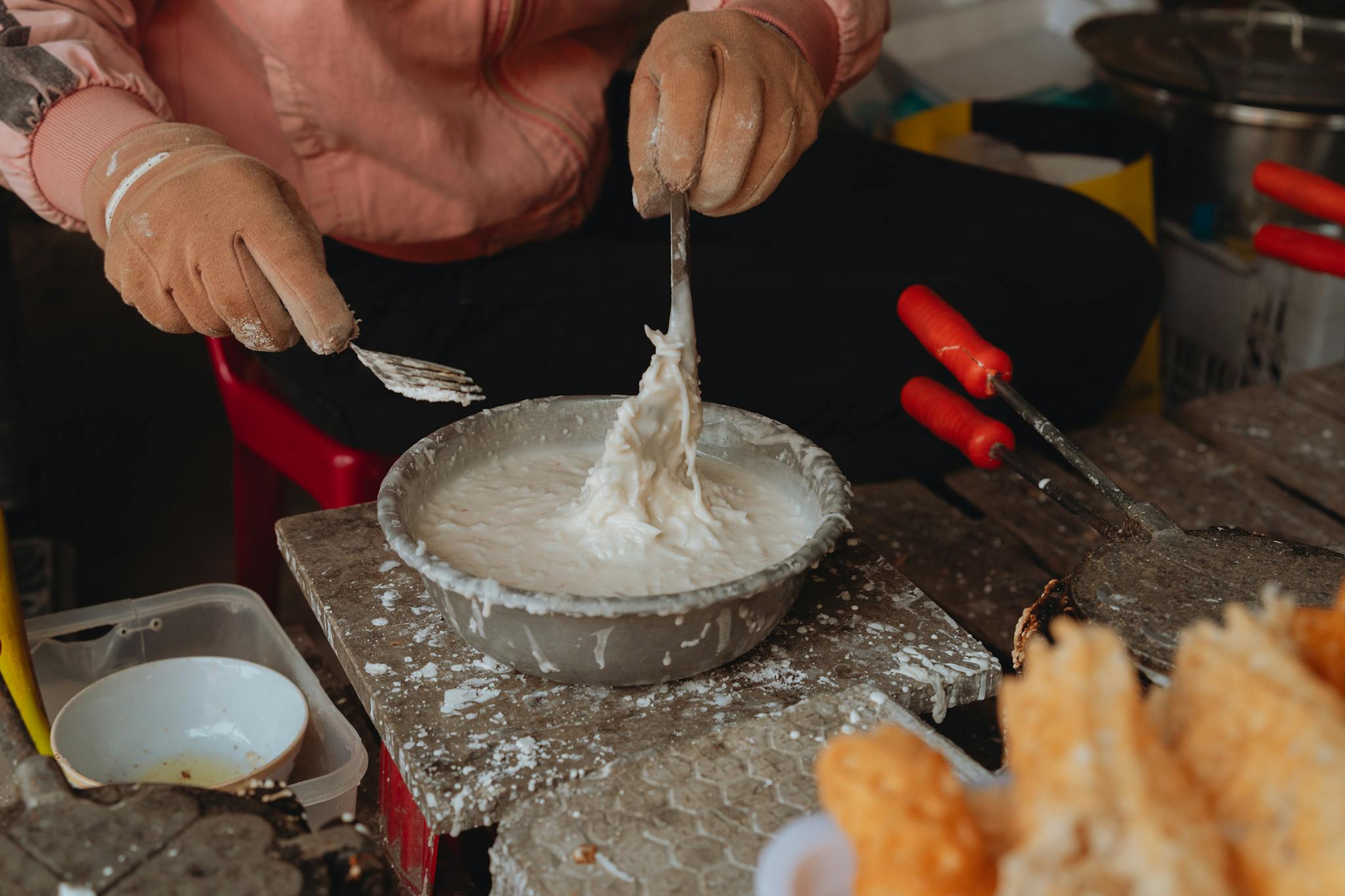 A vendor prepares traditional street food in Bình Thuận, Vietnam with special tools.