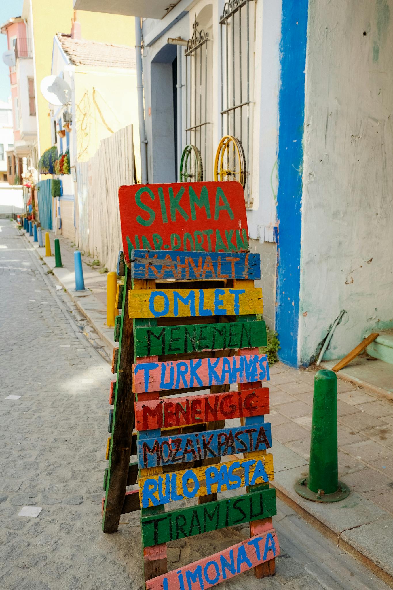 Colorful wooden menu board on a vibrant street, showcasing local eatery specials in an urban setting.